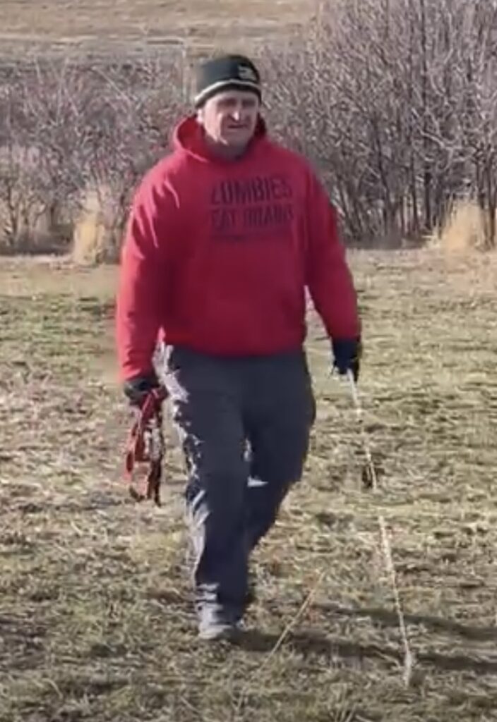 Kent Stewart, with his white cane, walking his dog in a local dog park